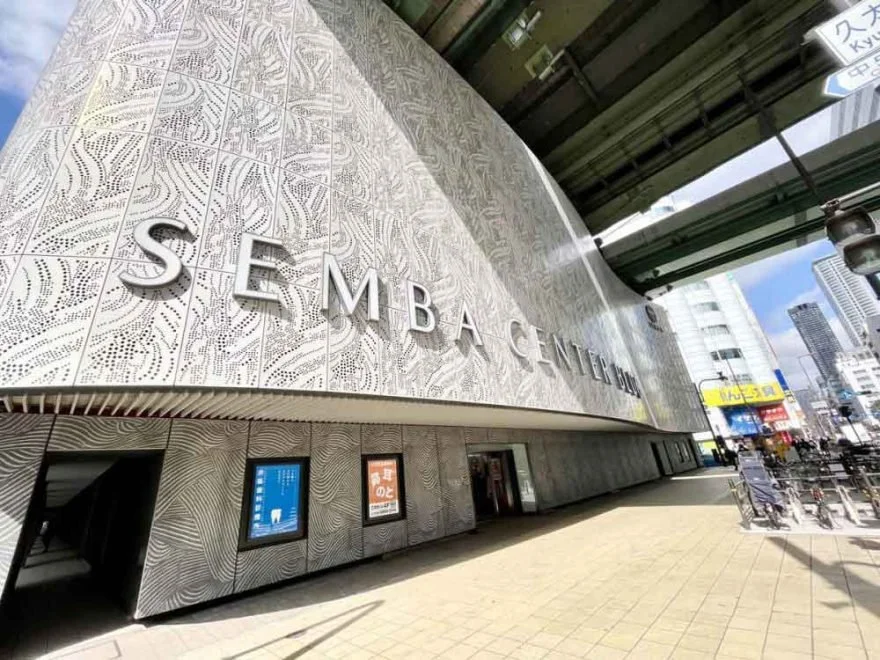 Signage for a coworking space visible directly from a metro station entrance near the Osaka Expo venue.